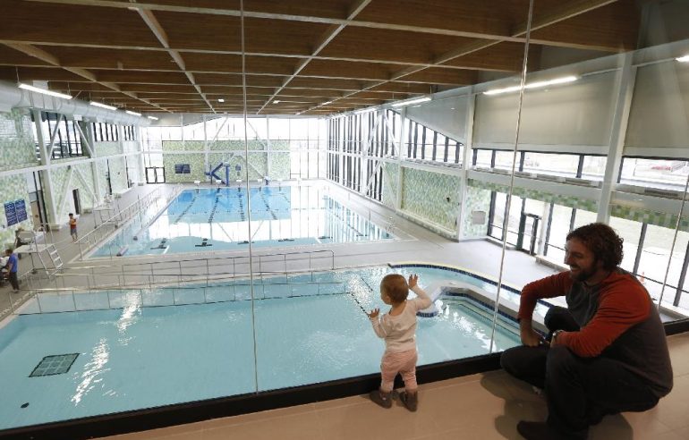 Élise Black, 1, with father Thierry, check out the pool at the grand opening of the new 160,000 square foot state-of-the-art Minto Recreation Complex in Barrhaven on Saturday morning, Nov. 29, 2014. Mayor Jim Watson was joined by fellow councillors and The Minto Group CEO Michael Waters for the official ceremony before public tours of the facility, which features two NHL sized skating rinks, a six lane-25 metre lap swimming pool with diving boards, a gymnasium, an artificial turf sports field, fitness facilities, a cafe and free Wi-Fi. (David Kawai / Ottawa Citizen)